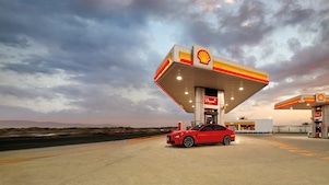 Voiture rouge à la pompe Shell V-Power