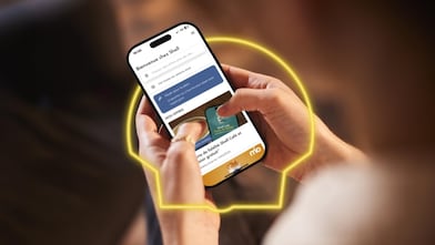 Une femme tient un téléphone avec l’application Shell ouverte et consulte les offres actuelles.
