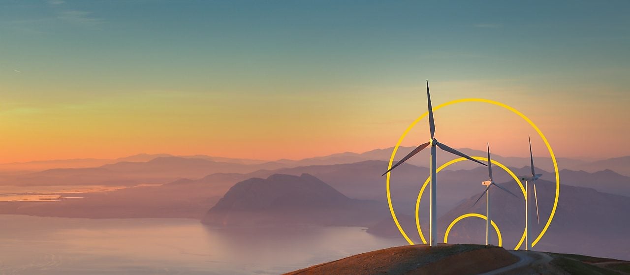 Hügelige Landschaft mit Windrädern in der Morgendämmerung