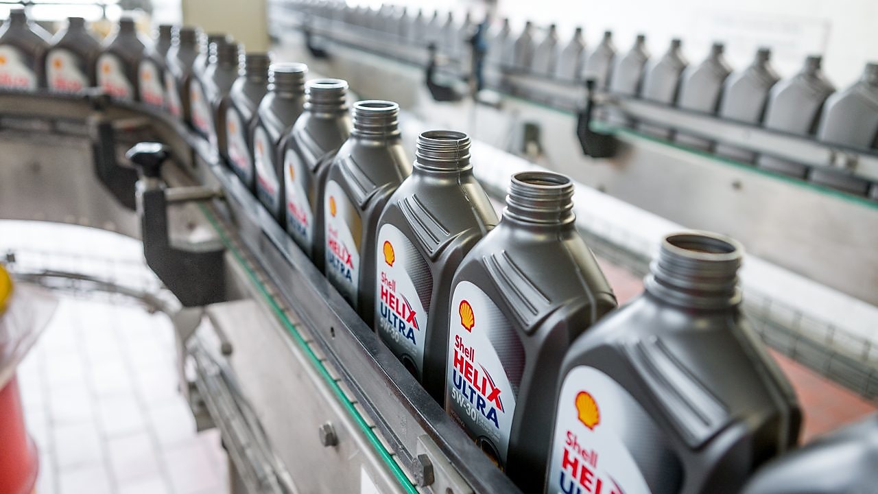 Verlängerter in einem Shell Café Porzellanbecher auf einem Holztisch