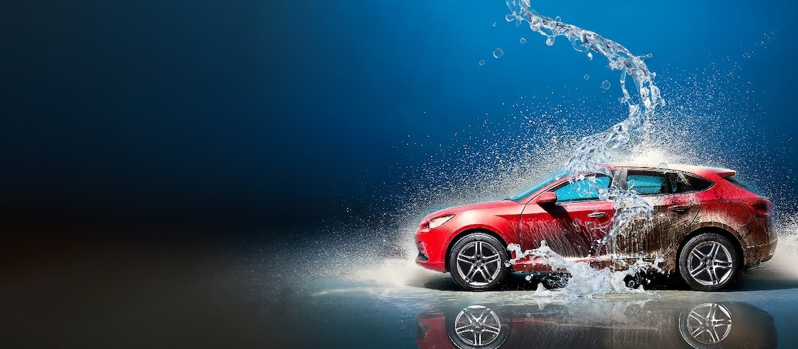Rotes Auto bei der Autowäsche