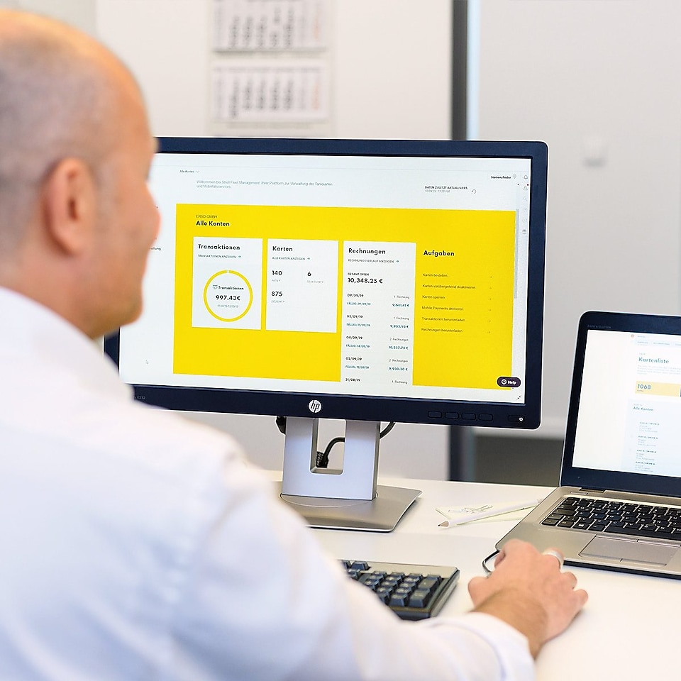 Ein Fuhrparkmanager sitzt vor seinem Computer, auf dem Shell Fleet Hub geöffnet ist.