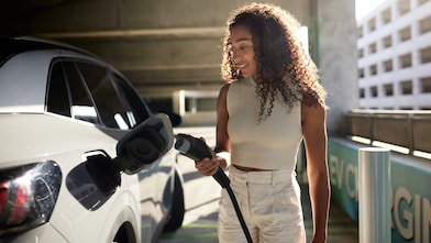 Eine Frau lädt ein Elektroauto