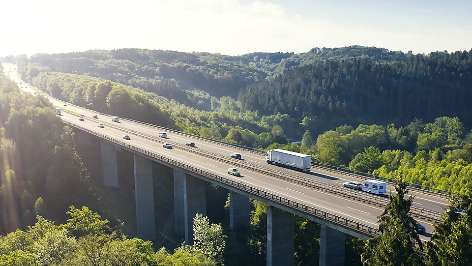 Eine Brücke führt über ein grünes Taal.