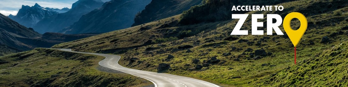 Eine Straße führt durch eine Bergregion. Die Überschrift auf dem Bild: Accelerate to zero.