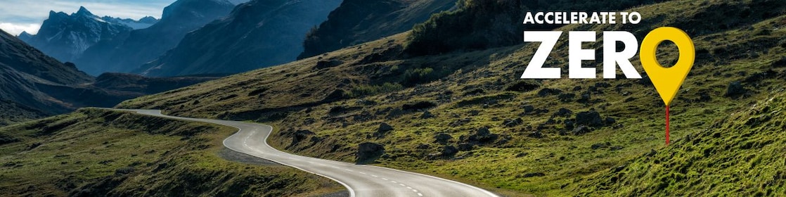 Eine Straße führt durch eine Bergregion. Die Überschrift auf dem Bild: Accelerate to zero.