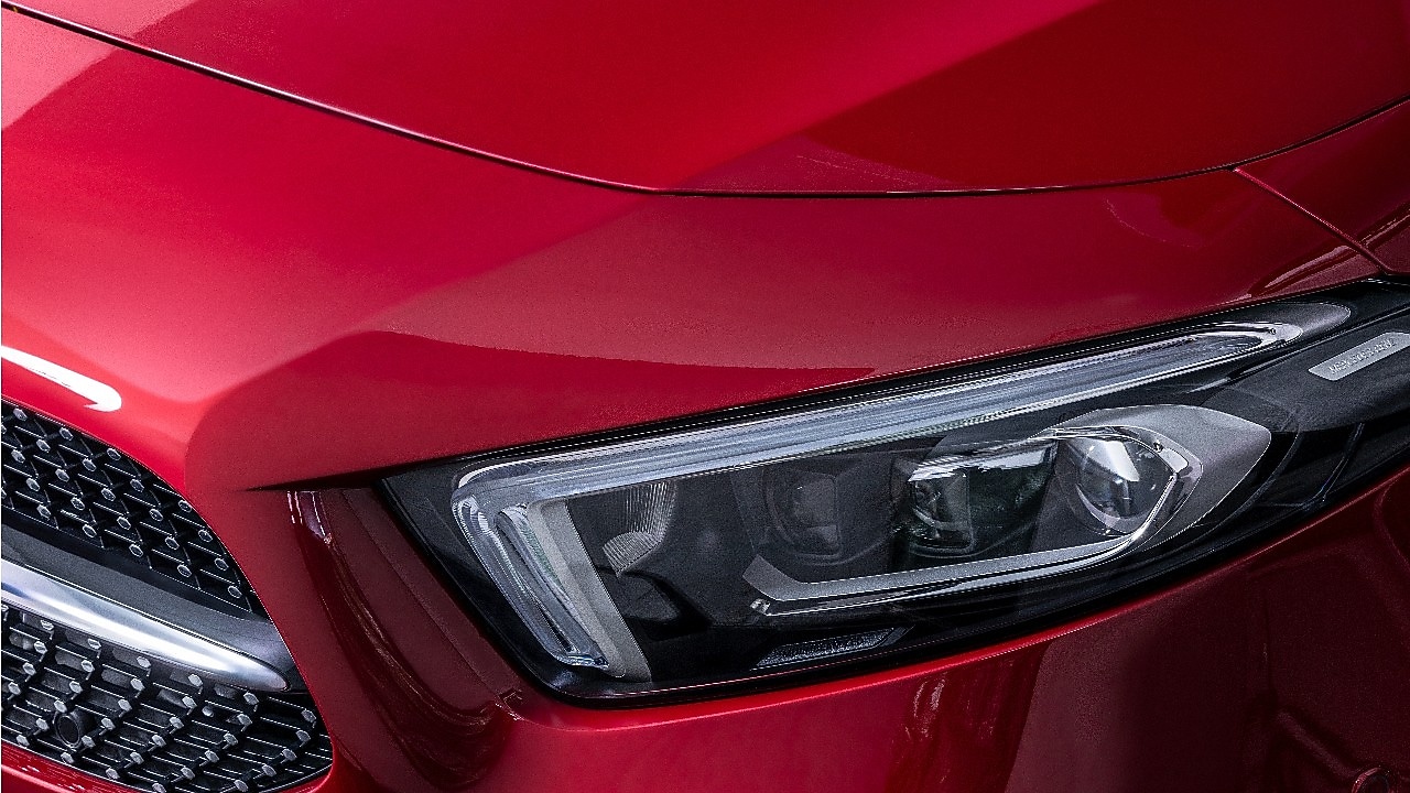 Detailansicht von einem Frontscheinwerfers eines roten Fahrzeugs in der Waschanlage, symbolisch für Shell Car Care.