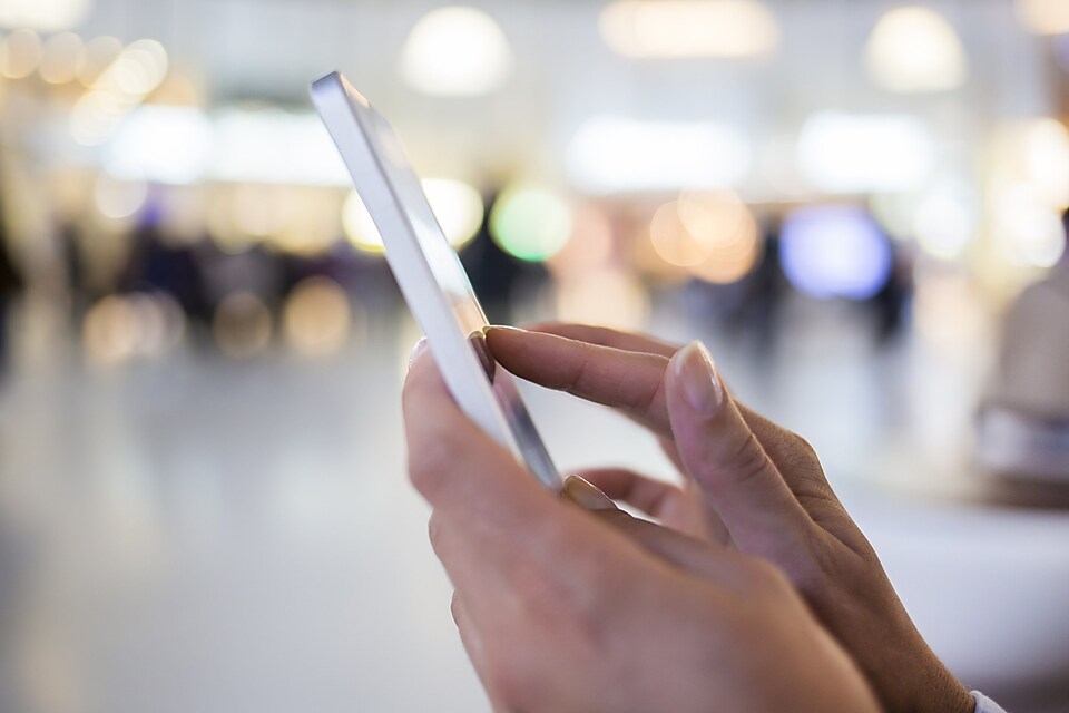 Eine Frau hält ein Smartphone in den Händen