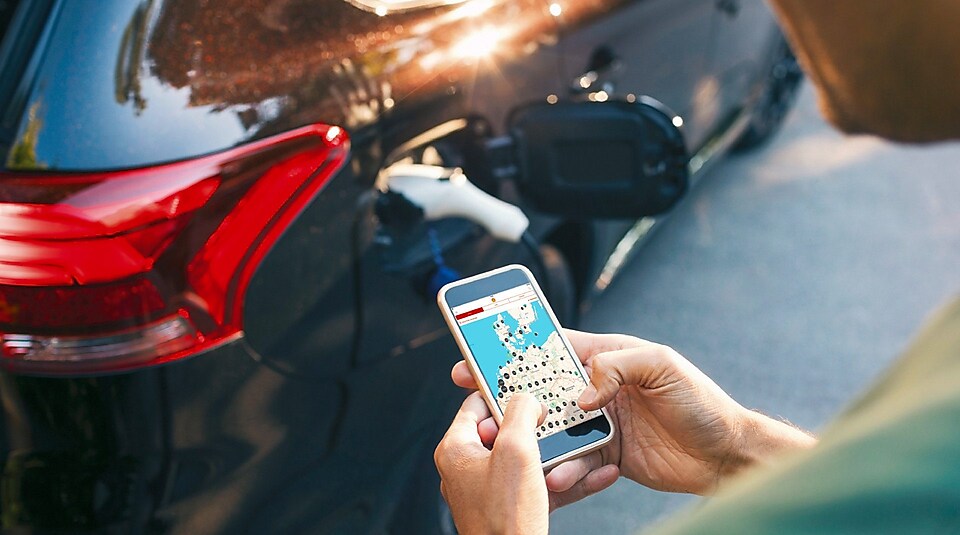 Ein Kunde nutzt die Maps App, während sein Elektroauto geladen wird