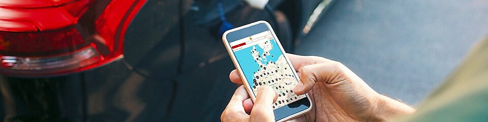 Ein Kunde nutzt die Maps App, während sein Elektroauto geladen wird