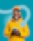 Lächelnder Mann in gelber Skijacke mit Wintermütze und Skibrille vor türkisem Hintergrund.