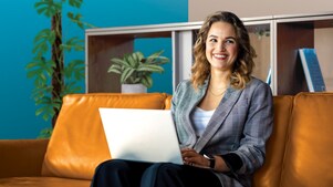 Personne assise sur un canapé en cuir brun avec un ordinateur portable