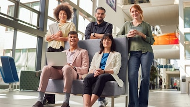 Cinq collaborateurs dans un bureau lumineux et moderne