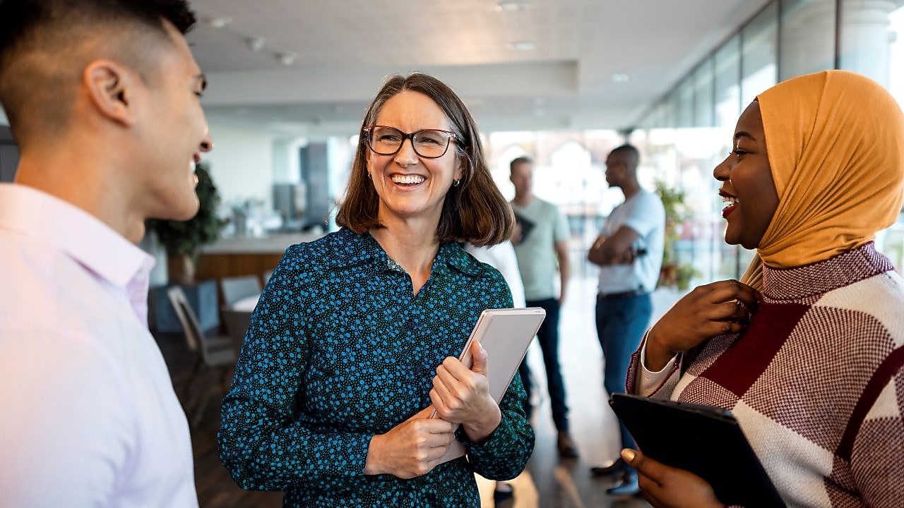 Trois collègues discutent dans un bureau