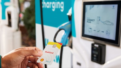 Personne à côté d’une borne de recharge Shell Recharge