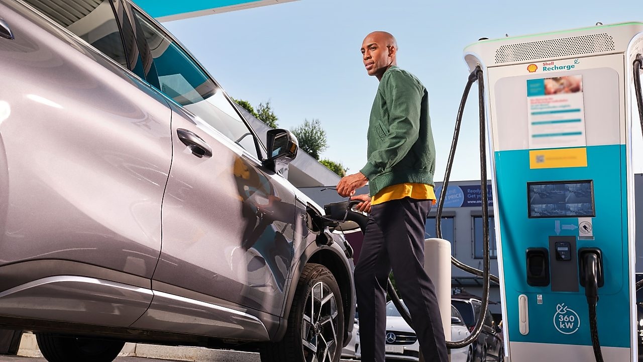 Personne à côté d’une borne de recharge Shell Recharge