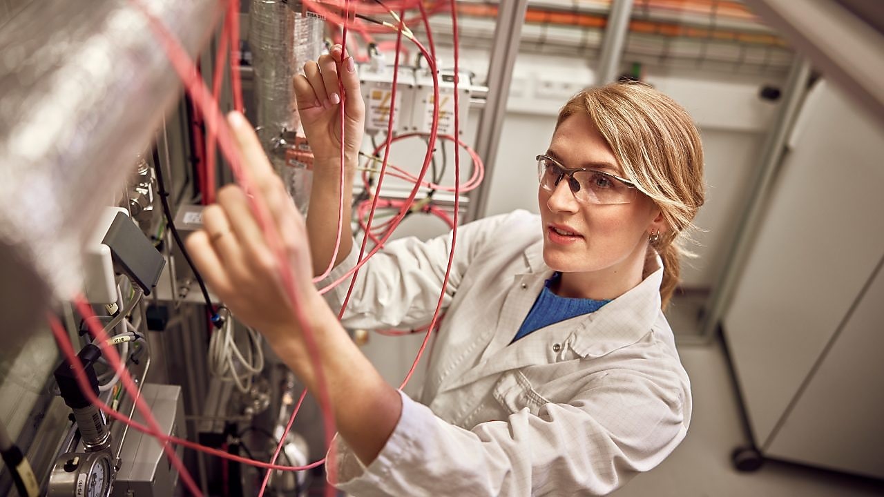 Personne en blouse de laboratoire travaillant avec une machine