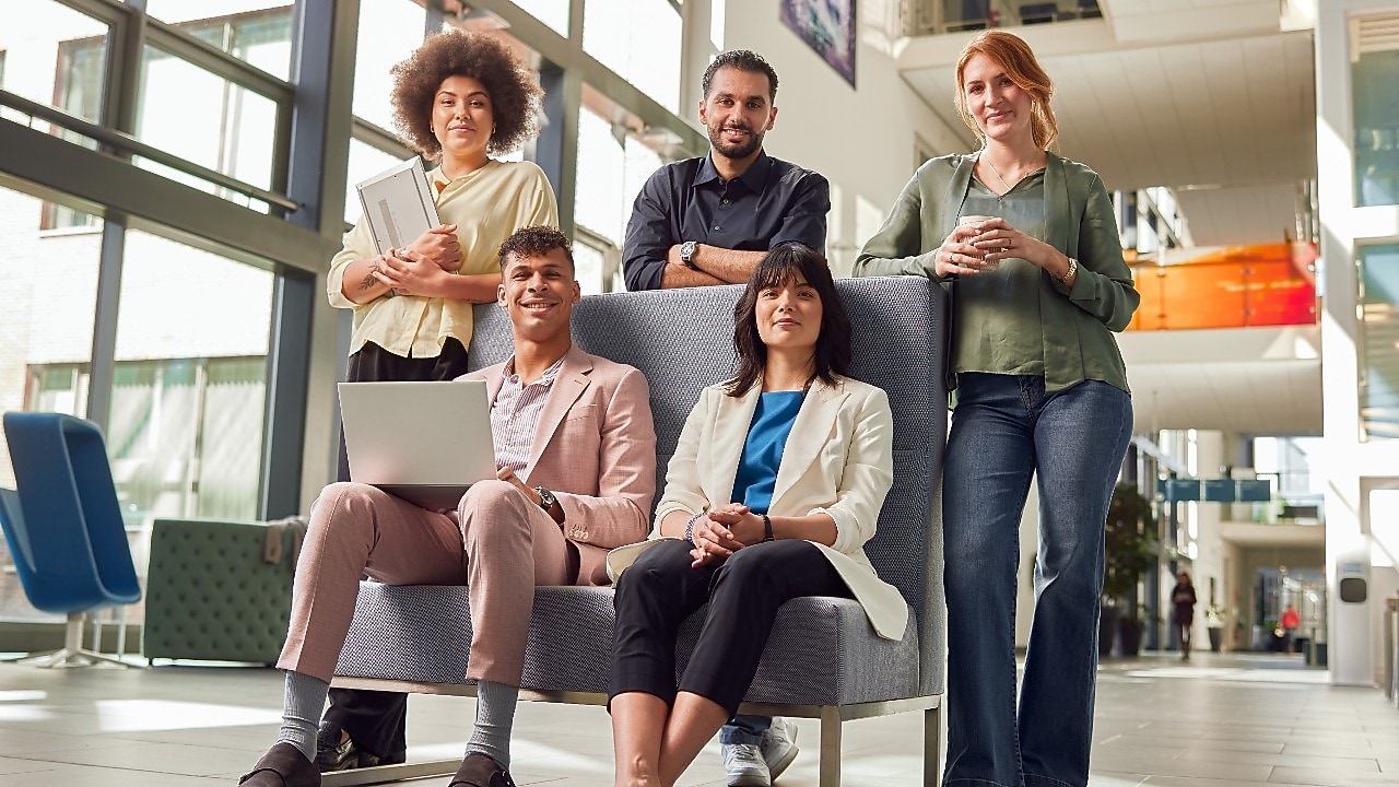 Cinq collaborateurs dans un bureau lumineux et moderne