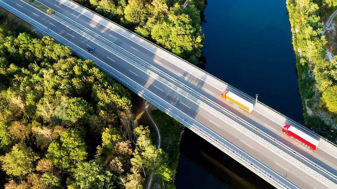 Café allongé servi dans un gobelet en porcelaine Shell Café posé sur une table en bois
