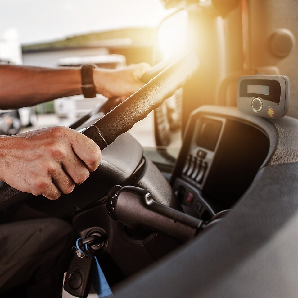 Dans le cockpit d'un camion, il y a un appareil de péage pour la solution EETS de Shell.