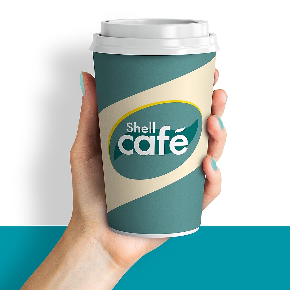 Une main tient un gobelet de café Shell sur un fond blanc-turquoise. Texte sur perturbateur jaune : Boisson chaude GRATUITE.