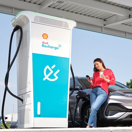 Femme utilisant une carte de recharge à une station Shell Recharge