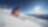 Skieur en veste rouge descendant une piste à Davos Klosters Mountains sous le soleil.