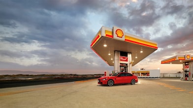 Voiture rouge à la pompe Shell V-Power