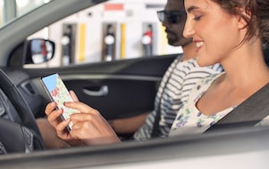 Une femme est au volant et saisit une adresse dans le système de navigation