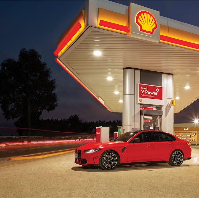 Voiture rouge à la pompe Shell V-Power