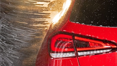 Detailansicht von einem Rücklicht eines roten Fahrzeugs in der Waschanlage, symbolisch für Shell Car Wash.