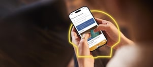 Une femme tient un téléphone avec l’application Shell ouverte et consulte les offres actuelles.