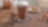 Un latte macchiato de Shell Café servi dans un verre haut posé sur une table en bois.