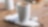 Café allongé servi dans un gobelet en porcelaine Shell Café posé sur une table en bois