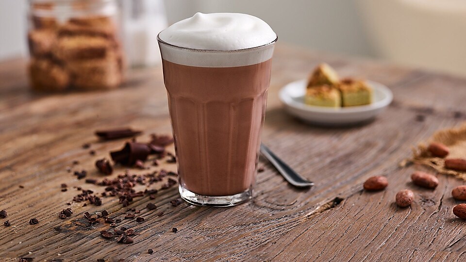 glass with hot chocolate on wooden table